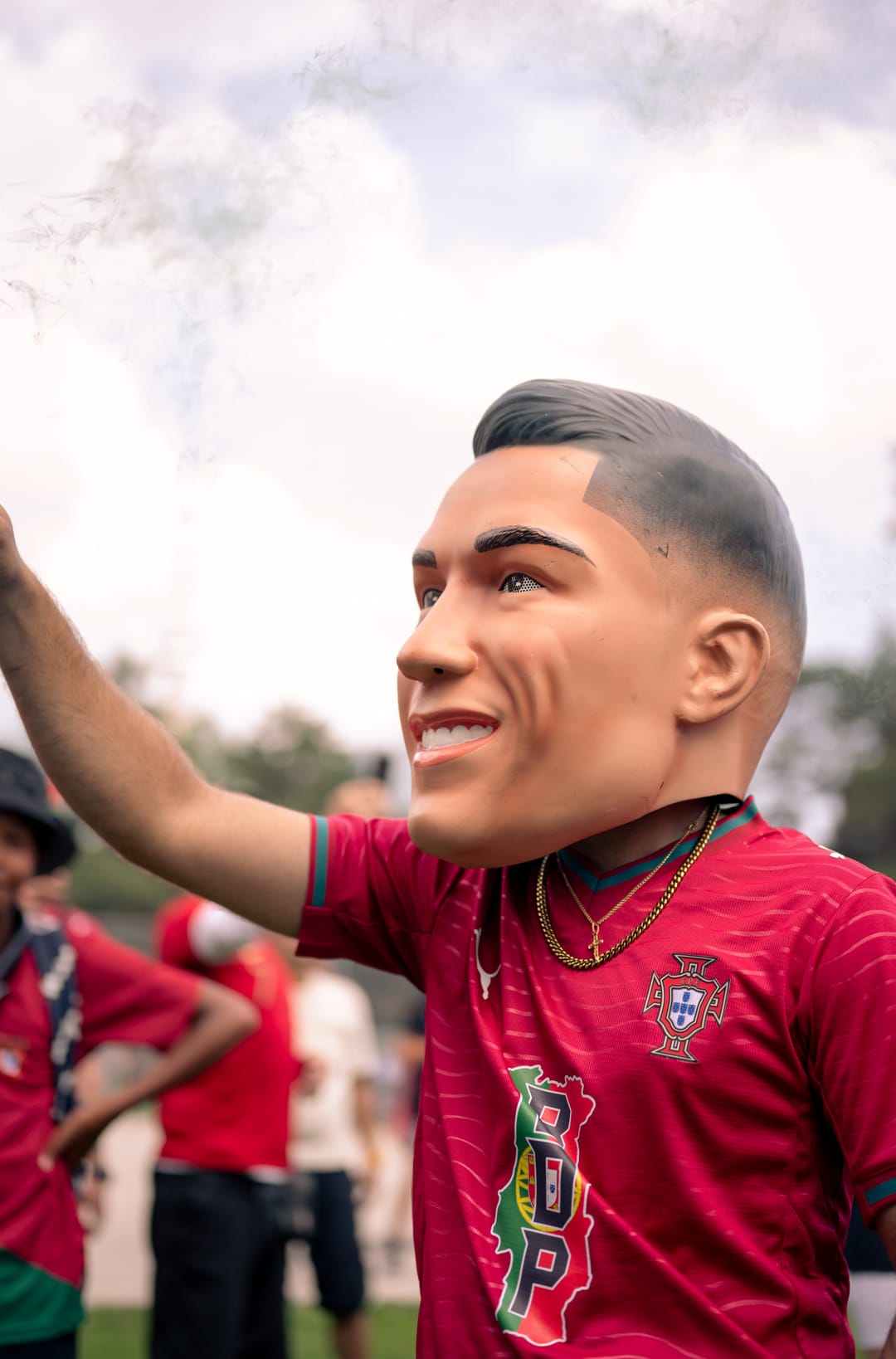 A fan in a large novelty head mask and a red Portugal jersey