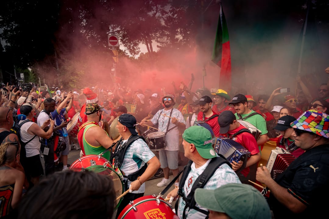 Portugal supporters playing drums in a haze of red smoke